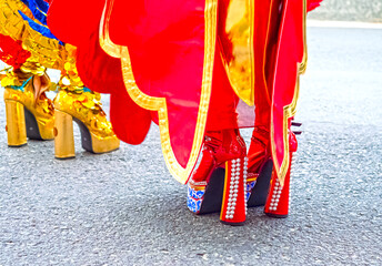Close-up of the shoes of the participants of the street costume parade. Bright details of the costumes, decorative shoes, elements of accessories, everything in motion and festive atmosphere