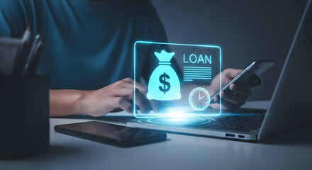 Businessman using laptop and phone with holographic loan and dollar sign, representing financial services and loan application process.