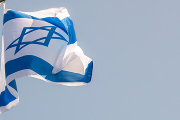 Large Israel flag waving in the wind. Israeli flag for advertising, holidays, achievements, festivals, elections. The Israeli flag flutters in the beautiful sky. Great for news.