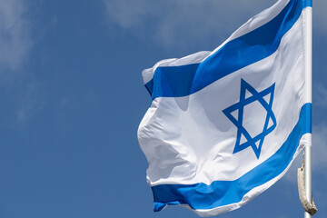 Large Israel flag waving in the wind. Israeli flag for advertising, holidays, achievements, festivals, elections. The Israeli flag flutters in the beautiful sky. Great for news.