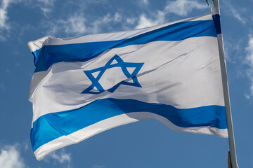 Large Israel flag waving in the wind. Israeli flag for advertising, holidays, achievements, festivals, elections. The Israeli flag flutters in the beautiful sky. Great for news.