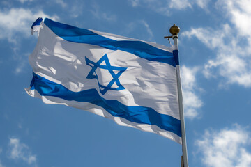 Large Israel flag waving in the wind. Israeli flag for advertising, holidays, achievements, festivals, elections. The Israeli flag flutters in the beautiful sky. Great for news.