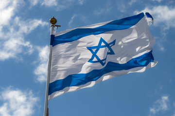 Large Israel flag waving in the wind. Israeli flag for advertising, holidays, achievements, festivals, elections. The Israeli flag flutters in the beautiful sky. Great for news.