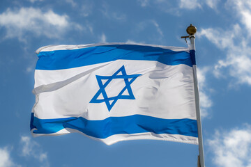 Large Israel flag waving in the wind. Israeli flag for advertising, holidays, achievements, festivals, elections. The Israeli flag flutters in the beautiful sky. Great for news.