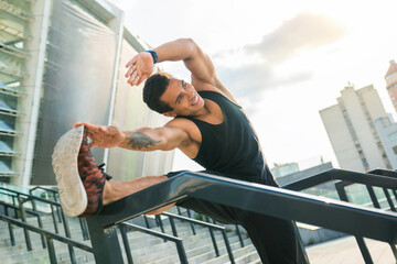 Having a good stretch. Handsome young African man in sports clothing stretching while warming up...