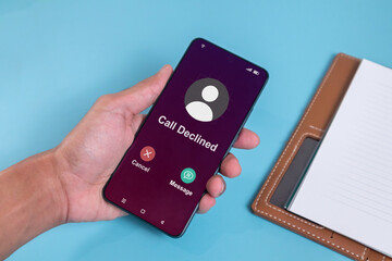 Man holding smartphone with Call Declined screen. Rejected phone call concept.