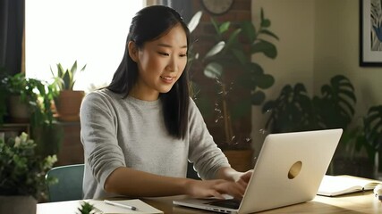 Young woman in video conference call from home office using laptop, remote work scene - Powered by Adobe