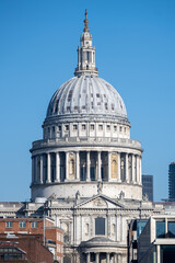 Obraz premium The magnificent dome of St. Paul's Cathedral rises majestically against a clear blue sky. This iconic landmark showcases London's rich architectural history and attracts many visitors daily.