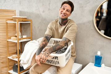 Charming tattooed individual enjoys laundry day in a cozy home environment filled with warmth