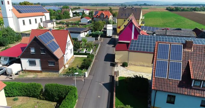 European city with lots of solar panels on roof. Solar panels on the roofs of private houses, top view. Utilization of solar energy in everyday life. Rooftop solar panels, solar panels on buildings