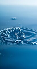 Serene blue water drop impact: clean, abstract, tranquil macro photography