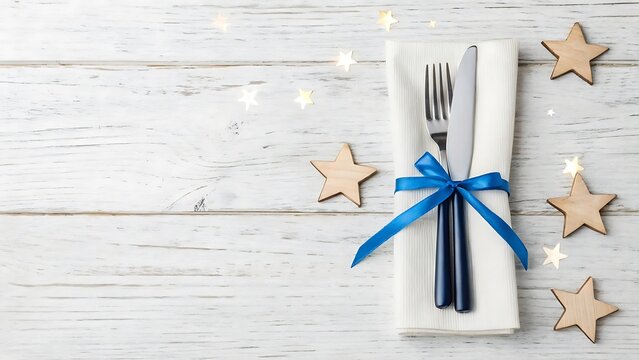 Elegant place setting with fork and knife tied with blue ribbon and star decorations