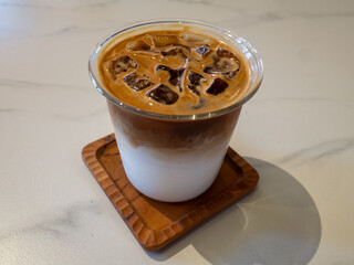 Iced coffee on wooden coaster