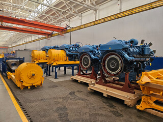 A large industrial building with a blue engines and yellow electric motor color scheme. The...