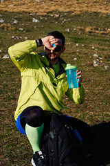 Thirsty Hiker Replenishes Energy with Water During a Well Earned Mountain Break.