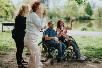 Four friends, including two in wheelchairs, engaging in a playful and cheerful moment blowing soap bubbles, showcasing happiness and inclusivity in a serene park environment.