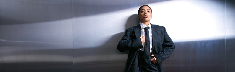Young woman exudes confidence and elegance in chic attire against modern backdrop