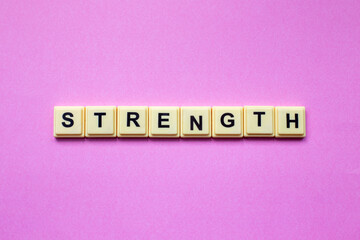 Strength word with alphabet cubes isolated on pink background

