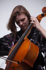 Woman playing cello, close-up, bow and instrument visible.