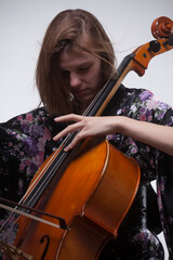 Woman playing cello, wearing floral kimono, close-up.