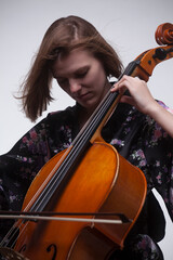 Woman playing cello, close-up, studio shot.