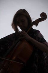 Woman Playing Cello, Silhouette Against Light Background