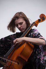 Woman playing cello, close-up, against a white background.