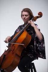 Woman playing cello wearing floral robe