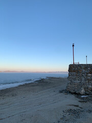 The pier at sunset. Spring, the ice melts in the lake. Blue sky 