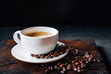 Coffee cup and coffee beans on gray background,  Espresso coffee cup aromatic on a wooden tray