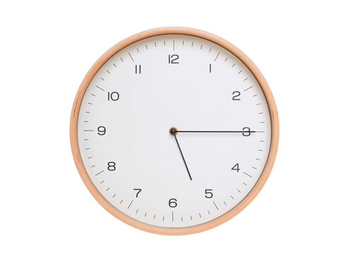 Minimal wall clock with light wood frame and white face displaying 05:15 or 17:15. Perfect for clean, modern concepts about time and scheduling.