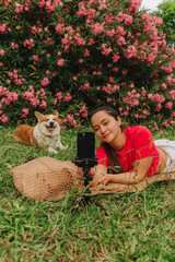 Young girl with Corgi recording video on phone share via app her travel vacation. Gen Z influencer...