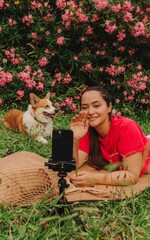 Young girl with Corgi recording video on phone share via app her travel vacation. Gen Z influencer...