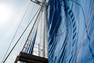A captivating point-of-view shot capturing the view of the majestic Phinisi sail from onboard. The...