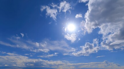 Azure sky with fluffy clouds and sunbeams piercing through, serene and expansive natural scenery.