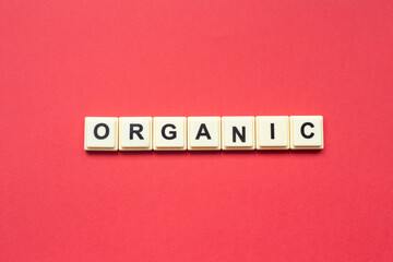Organic word with alphabet cubes isolated on red background
