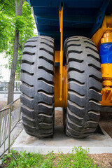 A pair of wheels of a large black mining car. Transport construction industry.