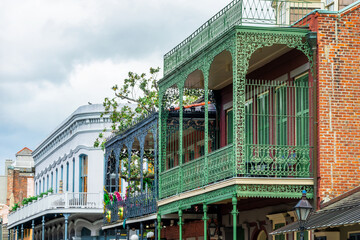Obraz na płótnie Canvas Balconies with intricate ironwork at a building in a street of the French Quarter, New Orleans architecture, Louisiana