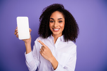 Woman in formal attire posing with a digital device against a purple background showcasing advertising concepts
