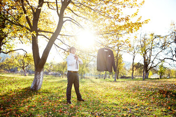 A man is standing in a field with a jacket hanging from a tree