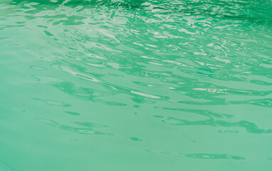 Abstract texture of a swimming pool water reflecting white light