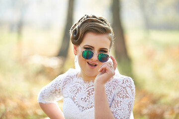 A woman wearing sunglasses and a white lace dress