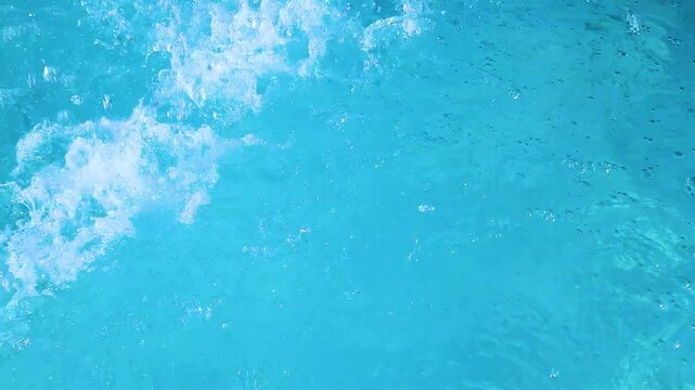 Video footage of blue clear water falling into a blue pool.