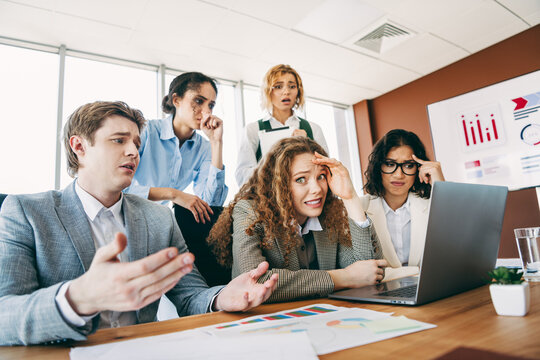 Group of business colleagues discussing a problem in a modern office setting.