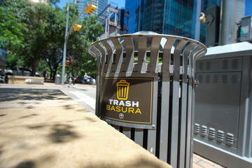 A Trash bin on the streets of Austin Texas, with spanish translated sign Basura