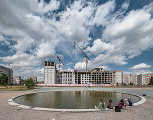 Urban circular decorative pool in front of a building under construction