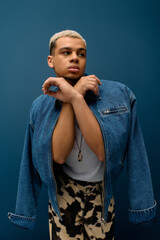 Confident young man with dyed hair showcases fashion in stylish denim jacket