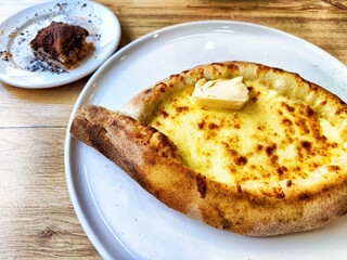 Delicious cheese bread served with butter and dessert on the side at a cozy eatery in the afternoon