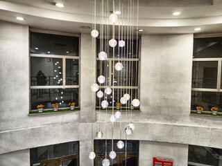 An elegant chandelier gracefully hangs from the ceiling of a contemporary lobby, where large...