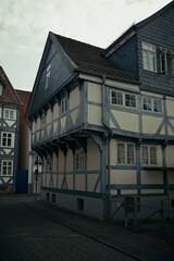 Fototapeta premium Traditional German half-timbered house with blue wooden beams and slate roofing on a quiet cobblestone street.